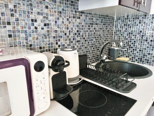 a kitchen with a sink and a microwave at Mondétour Paris centre - Urban flat in Paris