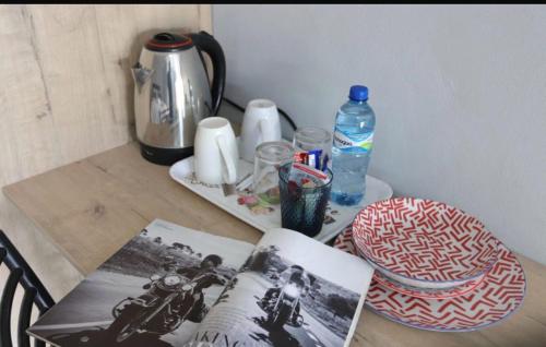 a table with a tea kettle and a book on it at 54 River Logde in Mokopane