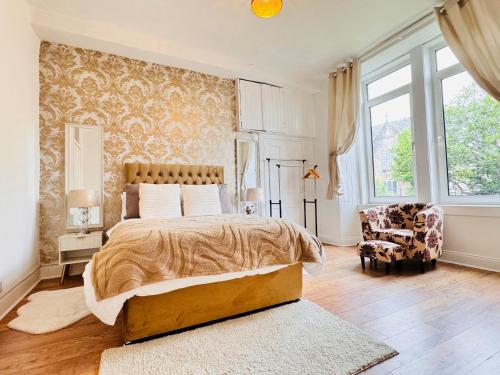 a bedroom with a large bed and a chair at THE RESTING LION - Gourock Town Center Holiday Home Apartment in Gourock