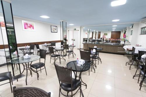 a restaurant with tables and chairs and a counter at Turis Hotel & Choperia in Dourados