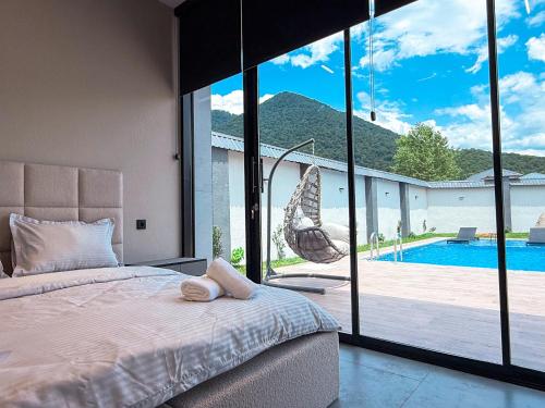 a bedroom with a bed and a view of a pool at Qafqaz Golden Loft in Gabala