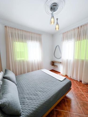 a bedroom with a bed and two windows at Appart-Hôtel Costa Azul - Bilal in Tetouan