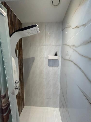 y baño con ducha y azulejos de mármol blanco. en AL Bela Vista, en Paredes de Coura