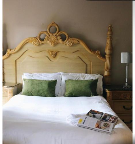 a bedroom with a white bed with a large headboard at 54 River Logde in Mokopane