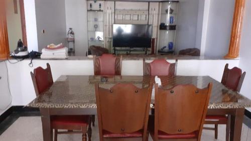 a dining room table with chairs and a television at Le Grand Refuge des Lilas in Casablanca