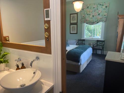 a bathroom with a bed and a sink and a tub at Villa Walton in Matamata