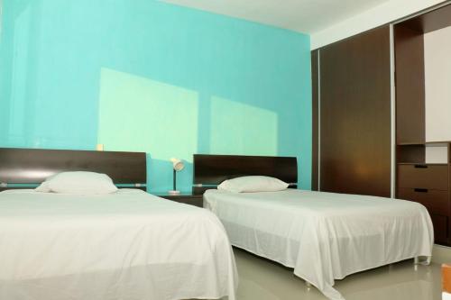 two beds sitting next to each other in a room at Oasis del Sol in Playa del Carmen