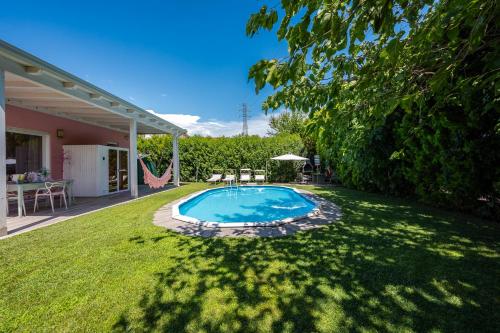 a backyard with a swimming pool in the grass at Villetta Tinmar Barbie House Verona in Verona