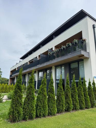 a building with a row of trees in front of it at Sheraa Home in Ķesterciems