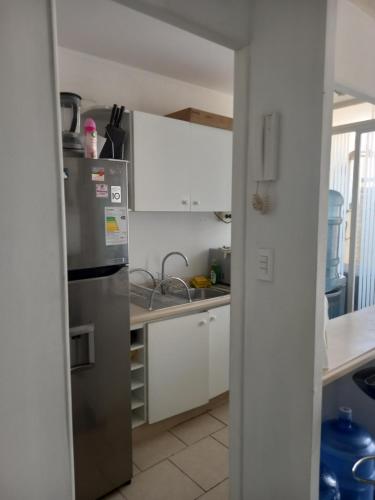 a kitchen with a stainless steel refrigerator and white cabinets at 306 pucara in Ovalle