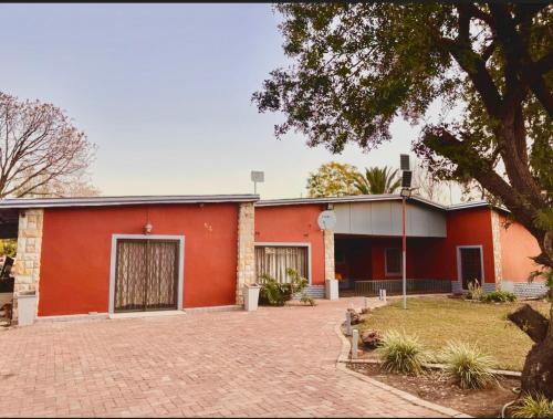 a red building with a driveway in front of it at 54 River Logde in Mokopane