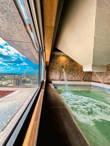 a swimming pool with a fountain in a building at Los Silos Hotel in Santa Fe