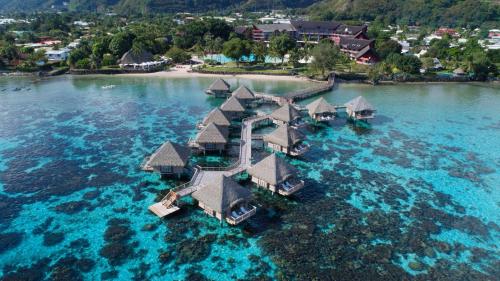 an island with a resort in the water at Tahiti Lagoon Resort in Punaauia