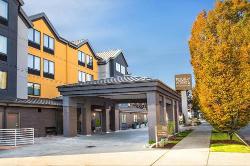 a building with a parking garage next to a tree at Four Points by Sheraton Downtown Seattle Center in Seattle