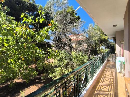 a balcony of a house with trees and bushes at Silver Paradeisi Apartment in Palaiá Fókaia