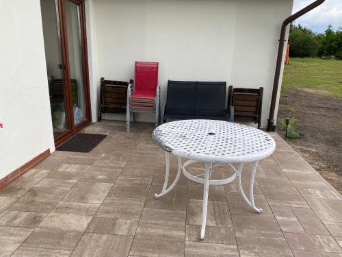 a white table and chairs on a patio at Domek Bory Tucholskie in Skorka