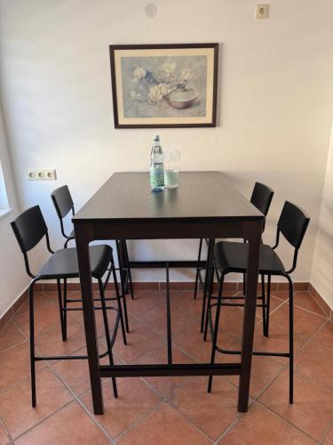 a dining room table with chairs and a bottle of water on it at Schöne Ferienwohnung am Waldrand in Detmold