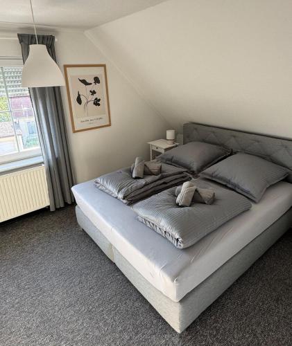 a bedroom with a large bed with gray pillows at Schöne Ferienwohnung am Waldrand in Detmold