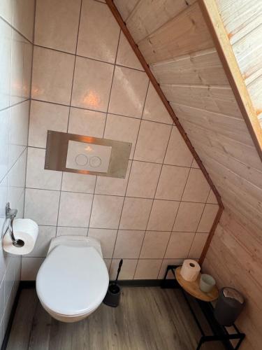 a bathroom with a white toilet and a toilet paper dispenser at Schöne Ferienwohnung am Waldrand in Detmold