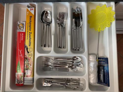 a plastic container filled with utensils and forks and spoons at Schöne Ferienwohnung am Waldrand in Detmold
