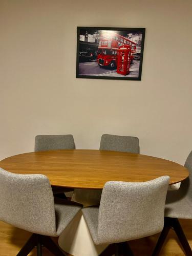 a wooden table with chairs and a picture of a fire truck at London House in Campinas
