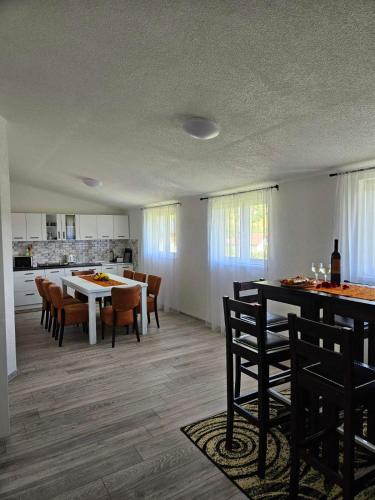 a dining room and kitchen with a table and chairs at Apartments Una Roots in Orašac
