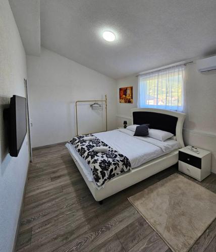a bedroom with a large bed and a television at Apartments Una Roots in Orašac