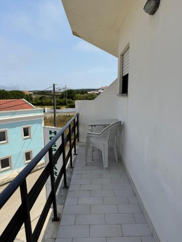a balcony with a table and chairs on a building at Alojamento Dona Inês de Castro in Atouguia da Baleia