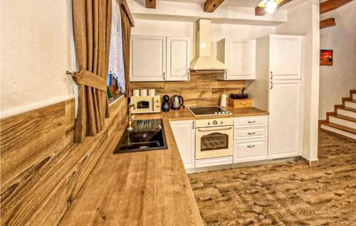 a kitchen with white cabinets and a sink and a stove at Amazing Home In Gospic With Wi-Fi in Gospić