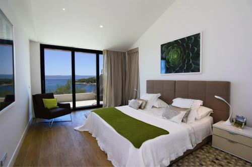 una camera da letto con un letto grande con una grande finestra di Villa Acona Selca Film Star Looks In A Glamorous Setting With Amazing Facilities Brac a Selca