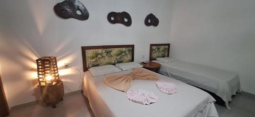 a bedroom with two beds and a lamp and lights at Espaço Sairé - 8 minutos da Praia in Alter do Chao