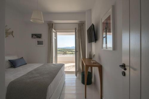 1 dormitorio con 1 cama y puerta con ventana en Luxury Paros Villa Villa Akaste Beautiful & Serene Glisidia, en Kampos