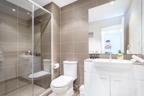 a bathroom with a toilet and a sink and a mirror at Subiaco Rooftop on Sheen in Perth