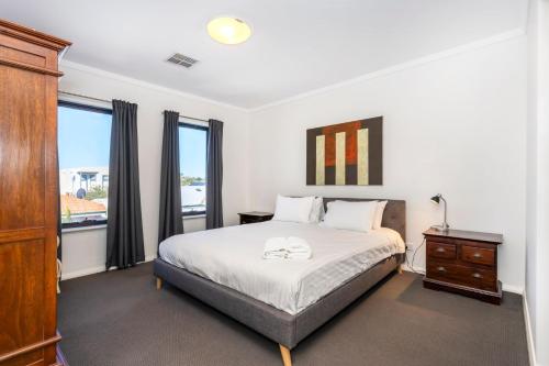 a bedroom with a bed and a dresser and a window at Scarborough Villa on Mickey in Perth