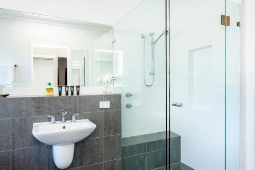 a bathroom with a sink and a glass shower at Scarborough Villa on Mickey in Perth