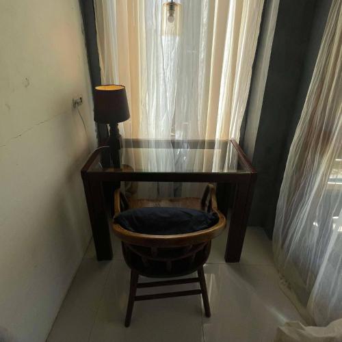 a table and a chair with a desk and a lamp at Querencia Siargao 