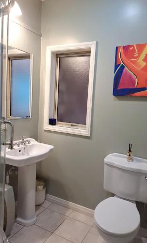 a bathroom with a toilet and a sink at NZ County Holiday Home in Kamo