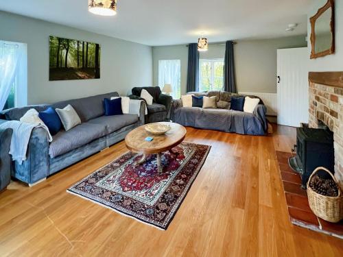 ein Wohnzimmer mit Sofa und Tisch in der Unterkunft Sandy Toes Cottage in Beechamwell