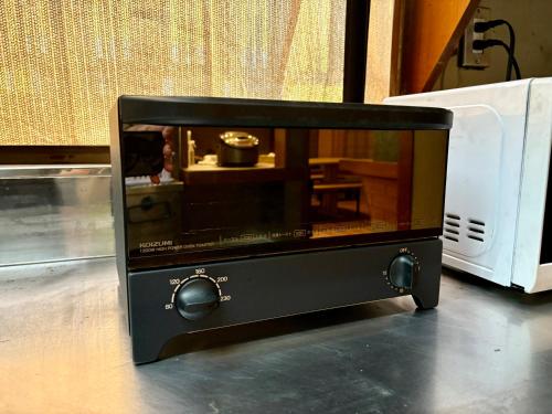 a black microwave with a model of a kitchen at Hav Living in Oshima