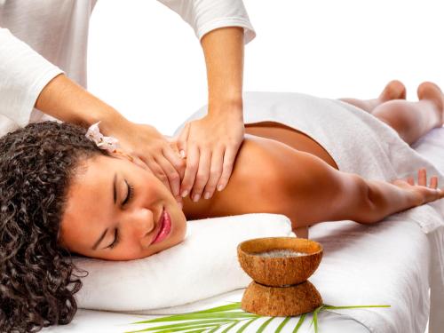a woman getting a massage from a therapist at Tombo Beach in Guarujá
