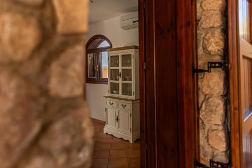 a kitchen with a glass cabinet and a mirror at Villa Luna Scopello in Castellammare del Golfo