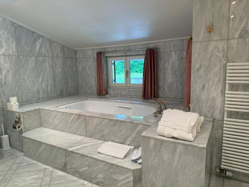 a large bathroom with a tub and a window at Chalet Felseneck - Ihr privates Ferienhaus in den bayerischen Alpen in Mittenwald