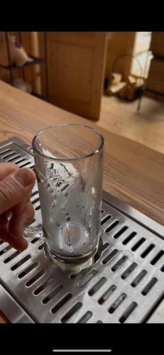 a glass sitting on top of a metal table at Wellness-Ferienwohnung mit Sauna, Massagen, beheizbarem Whirlpool & eigener Bierzapfanlage in Pomssen