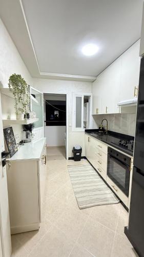 a kitchen with white cabinets and a white counter top at BARAKA APPART in Selouane