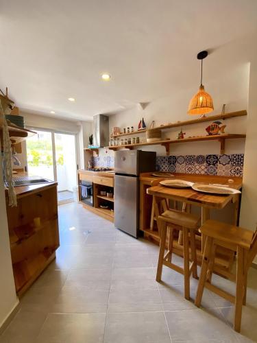 a large kitchen with a table and chairs and a counter at El Yaque Flow Beach, tu apartamento de playa in El Yaque