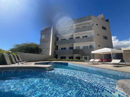 a building with a swimming pool in front of a building at El Yaque Flow Beach, tu apartamento de playa in El Yaque