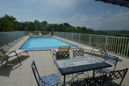 a patio with a table and chairs and a pool at Domaine Garmidou in Lucq-de-Béarn