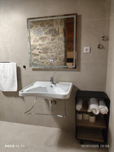a bathroom with a sink and a mirror and towels at Tapada das Carvalhas in Castelo Branco