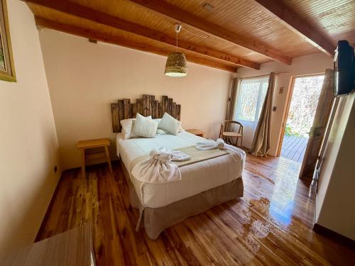 a bedroom with a large bed with a wooden headboard at Hotel Jireh in San Pedro de Atacama