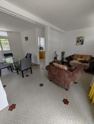 a living room with couches and a dining room at Appartement F3 Caracosy tout confort in Les Abymes
